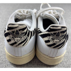 Second Half Supply Co, LLC adidas Stan Smith sneakers featuring white leather and zebra-print heel tabs, rear view.
