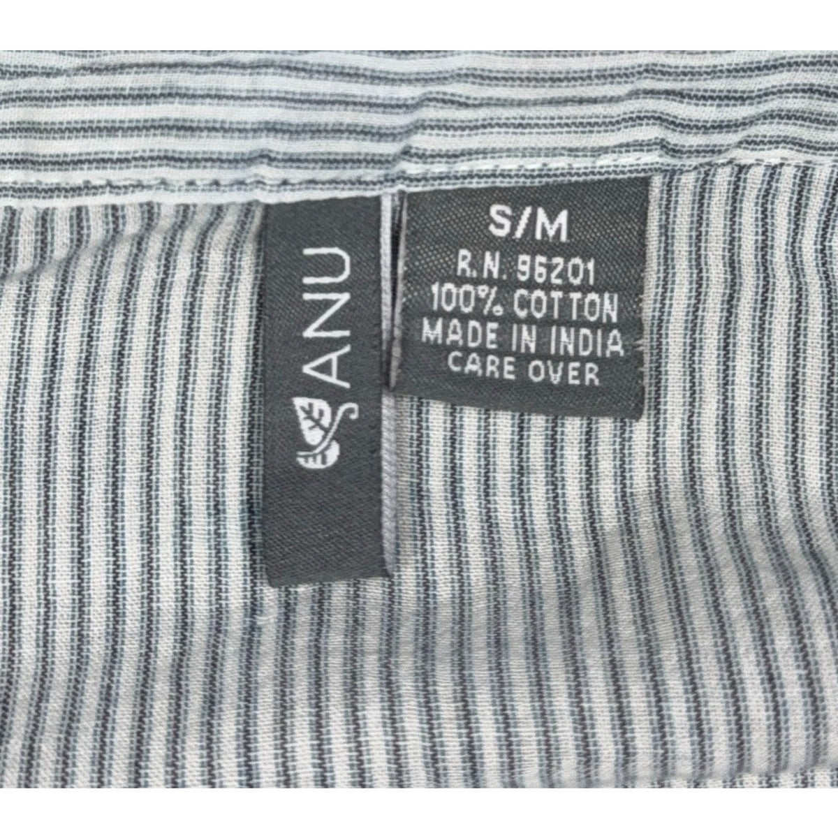 Second Half Supply Co, LLC ANU blouse fabric tag showing 100% cotton material and S/M size on blue-gray striped fabric