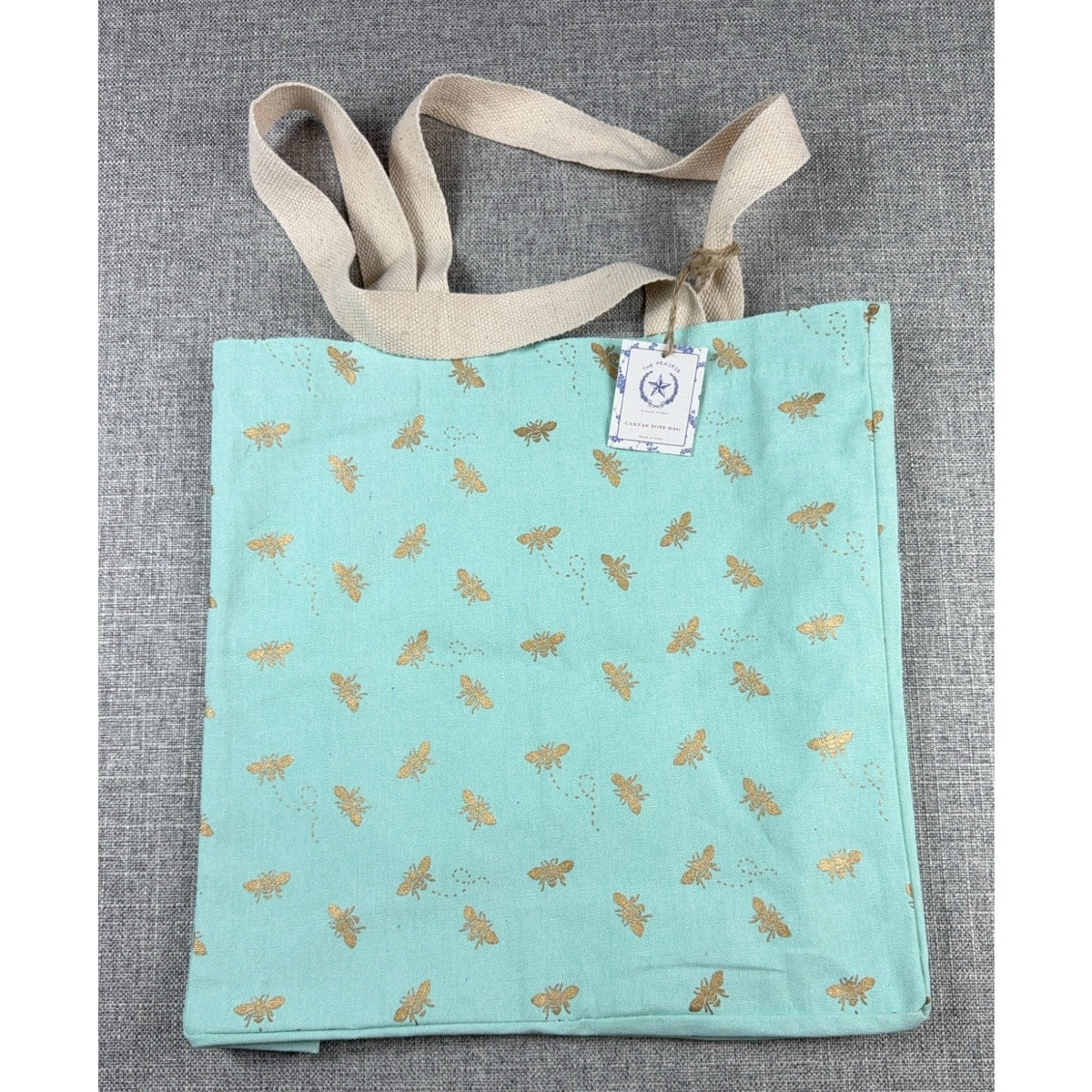 Second Half Supply Co, LLC aqua canvas tote bag with metallic gold bee print and natural cotton shoulder straps.