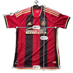 Second Half Supply Co, LLC Atlanta United 2023-24 authentic home jersey with red and black stripes and gold trim.