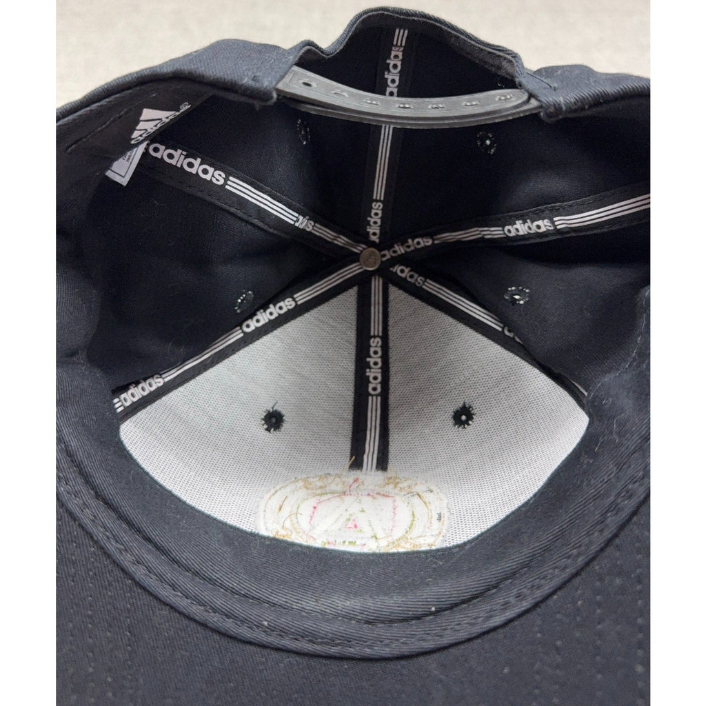 Interior view of a black Second Half Supply Co, LLC Atlanta United FC Adidas snapback hat showing branded tape.