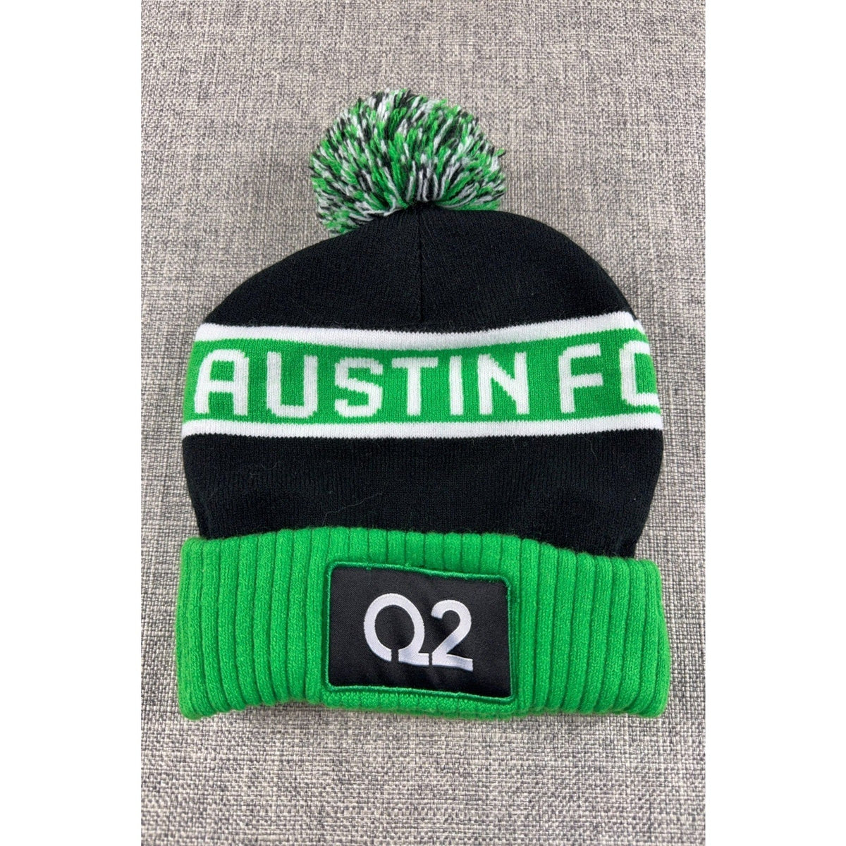 Second Half Supply Co, LLC Austin FC knit pom beanie in black and green with Q2 stadium branding and ribbed cuff