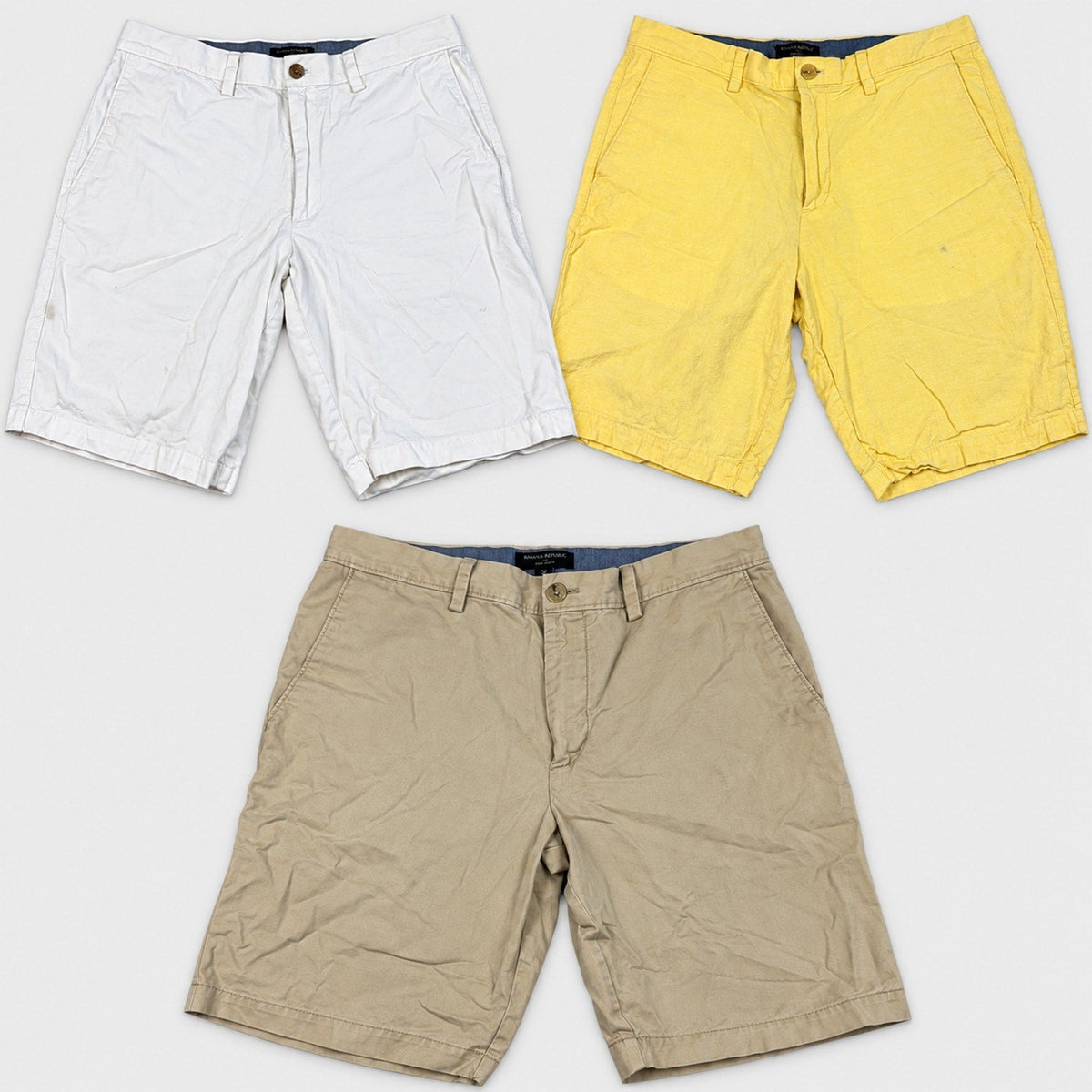 Second Half Supply Co, LLC bundle of three Banana Republic men's flat-front chino shorts in white, yellow, and khaki.