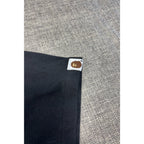 Second Half Supply Co, LLC black BAPE cotton t-shirt sleeve featuring a small woven Ape Head logo tab