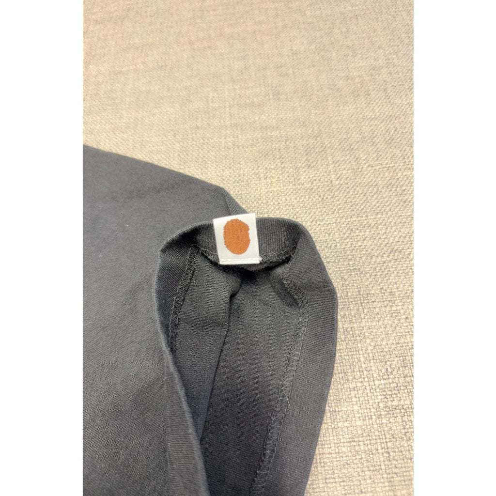Second Half Supply Co, LLC black BAPE cotton t-shirt sleeve featuring a small woven brown Ape Head logo tab