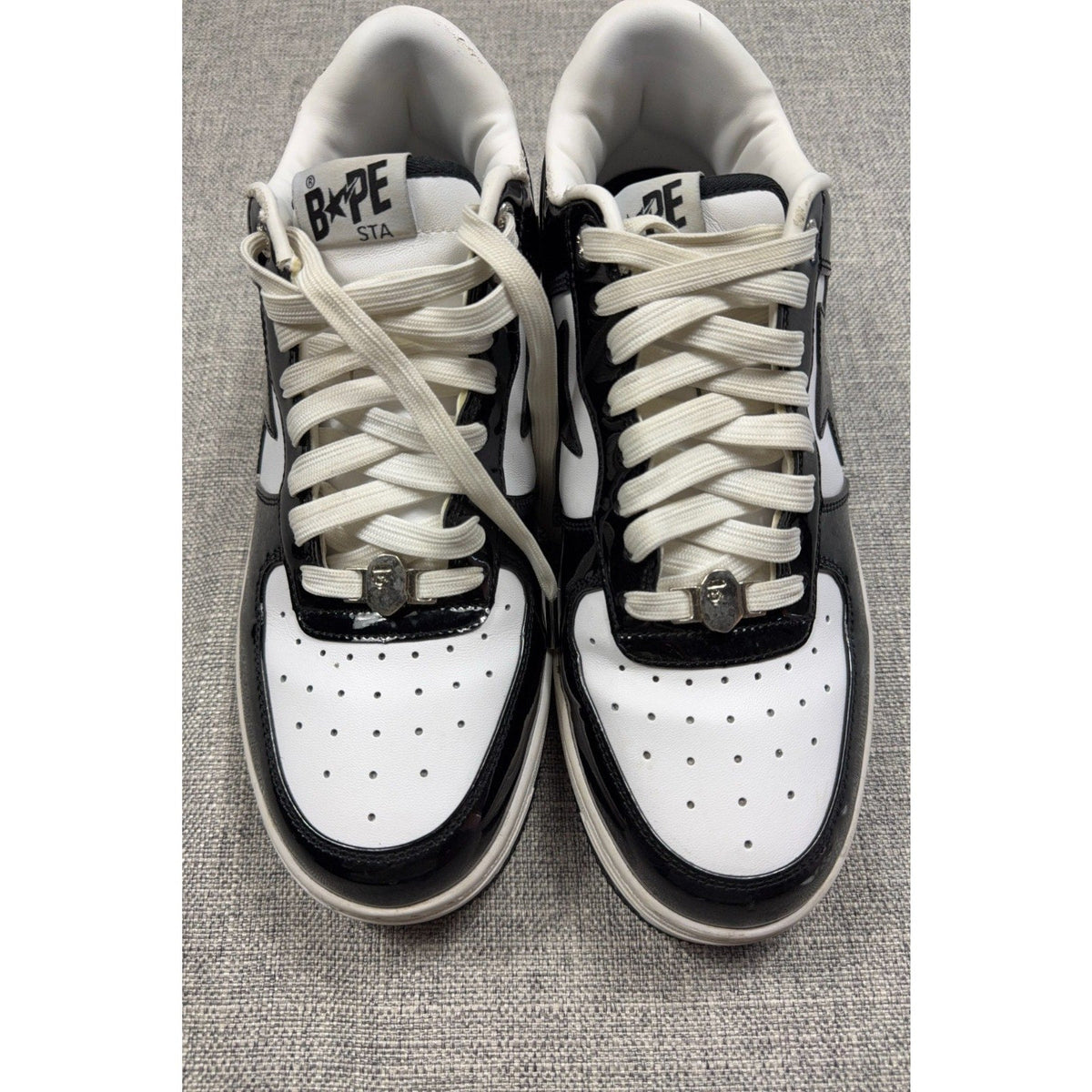 Second Half Supply Co, LLC BAPE STA low-top sneakers in black and white patent leather with silver lace ornaments