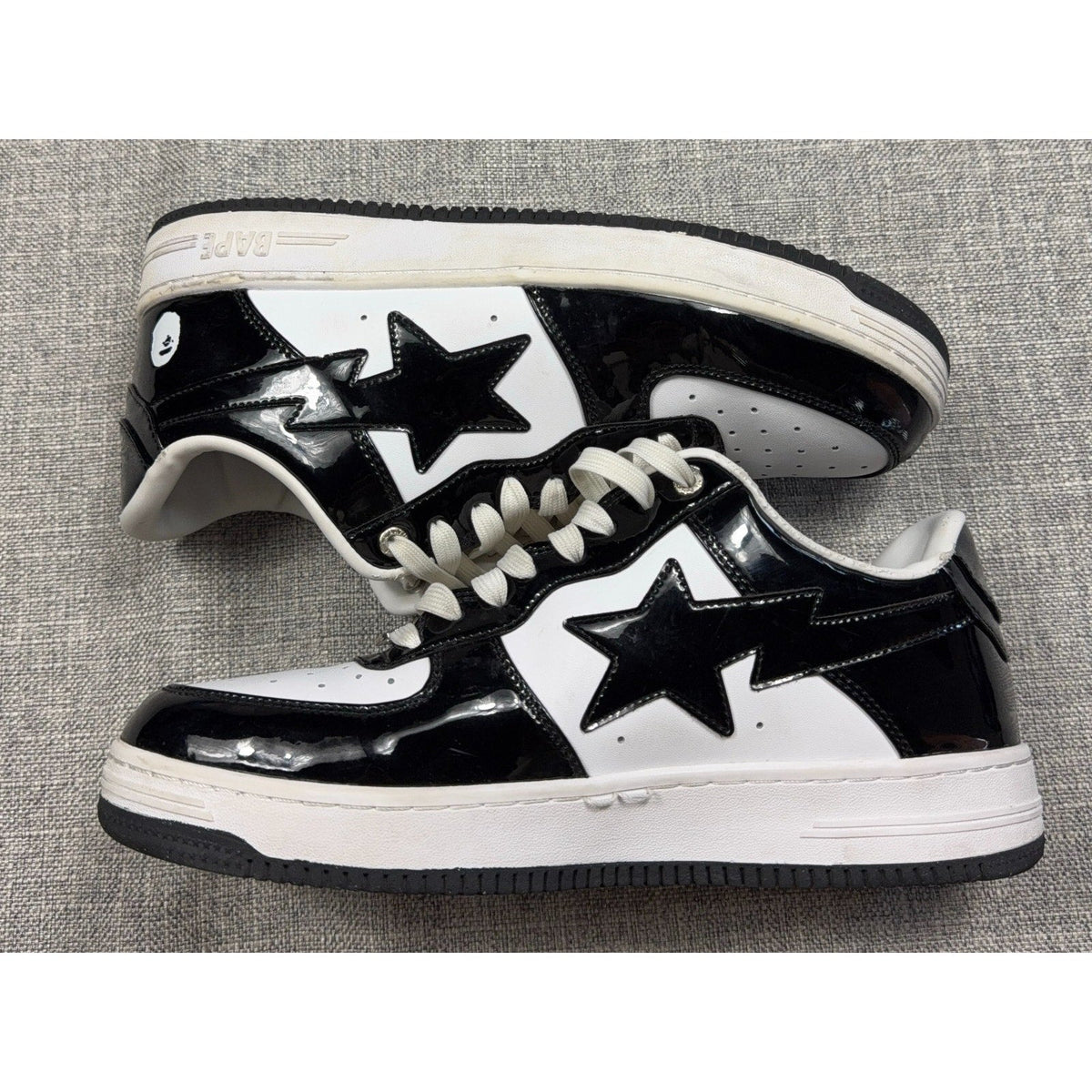 Second Half Supply Co, LLC BAPE STA low-top sneakers in black and white glossy patent leather with star side logos.