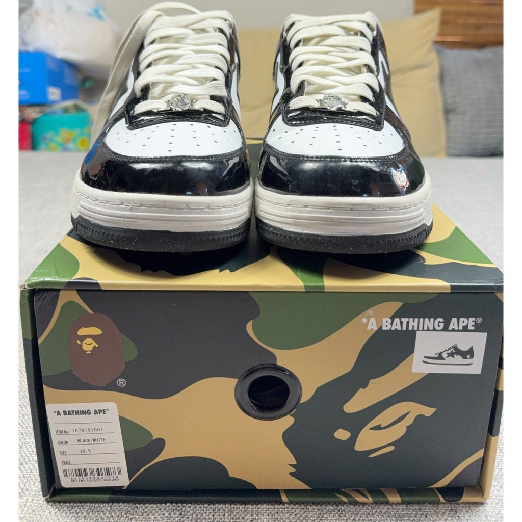 Second Half Supply Co, LLC BAPE STA low-top sneakers in black and white patent leather with silver lace ornaments.