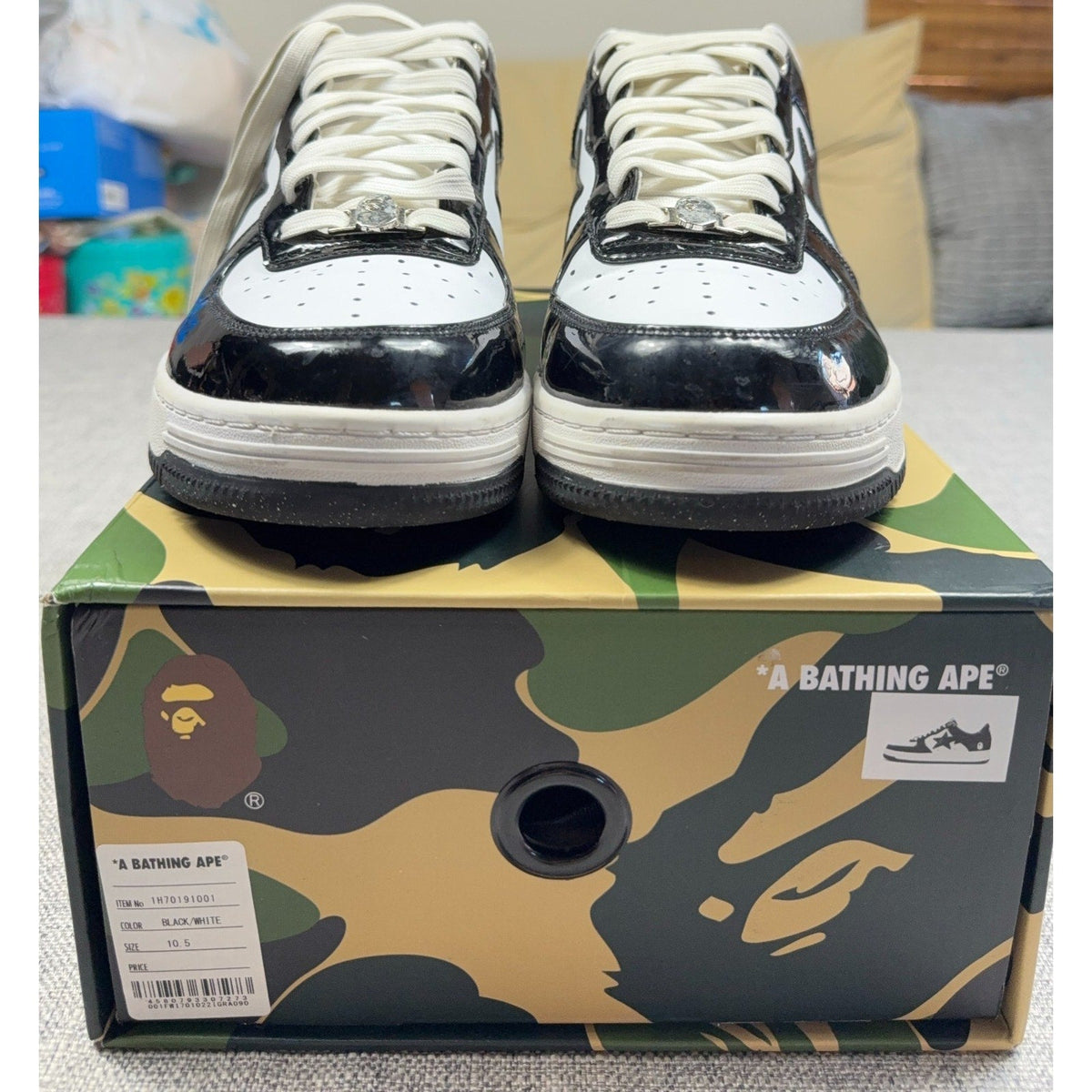 Second Half Supply Co, LLC BAPE STA low-top sneakers in black and white patent leather with silver lace ornaments.