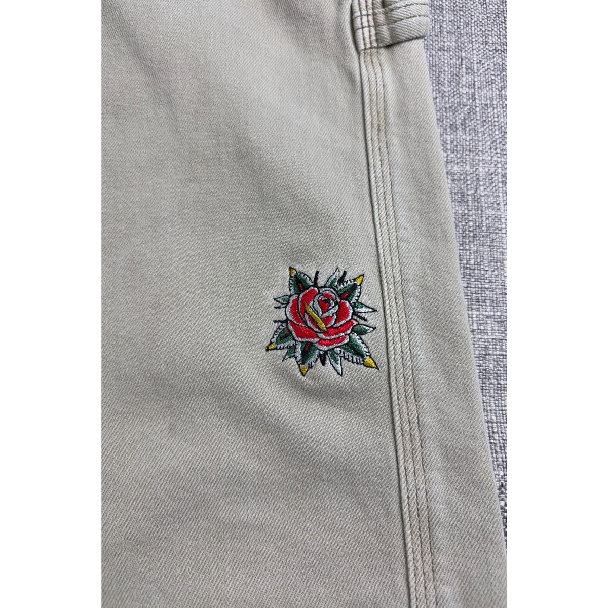 Second Half Supply Co, LLC light beige carpenter jeans featuring detailed American Traditional rose embroidery.