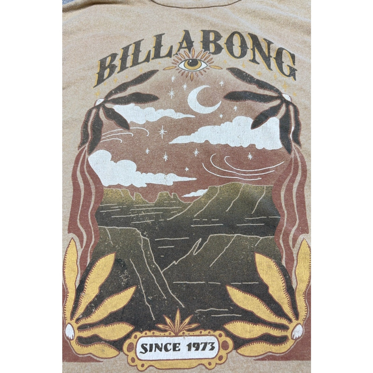 Second Half Supply Co, LLC tan Billabong boxy tee featuring a celestial moon, eye, and coastal landscape graphic.