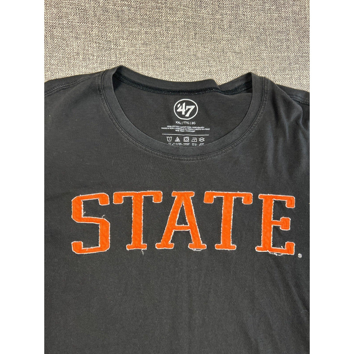 Second Half Supply Co, LLC black 47 long sleeve shirt with orange STATE appliqué lettering and crew neckline