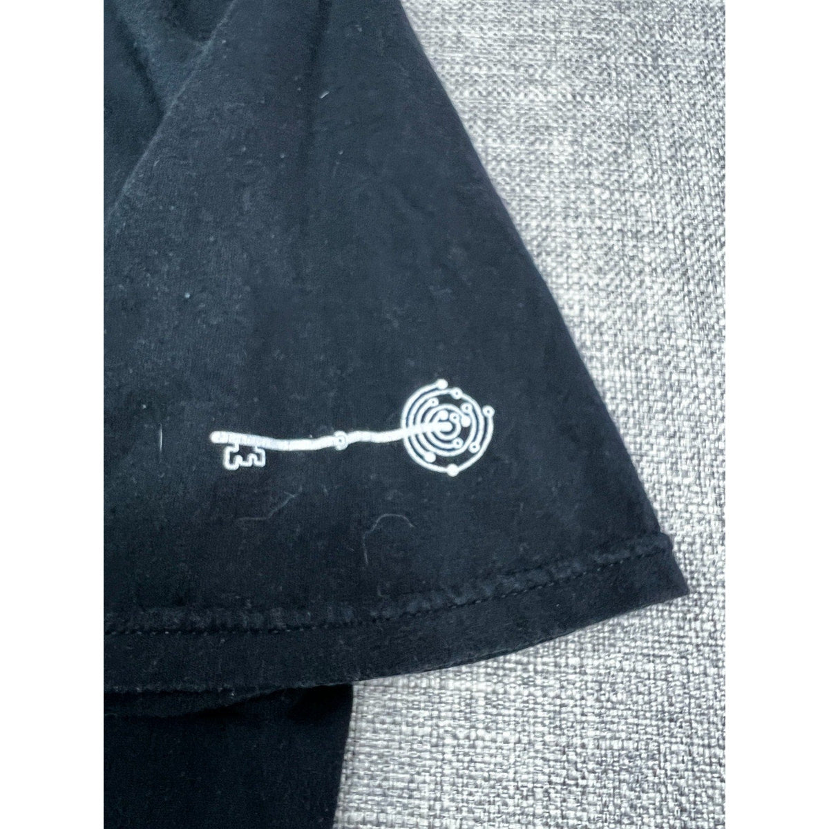 Second Half Supply Co, LLC black t-shirt sleeve featuring a white intricate key graphic print