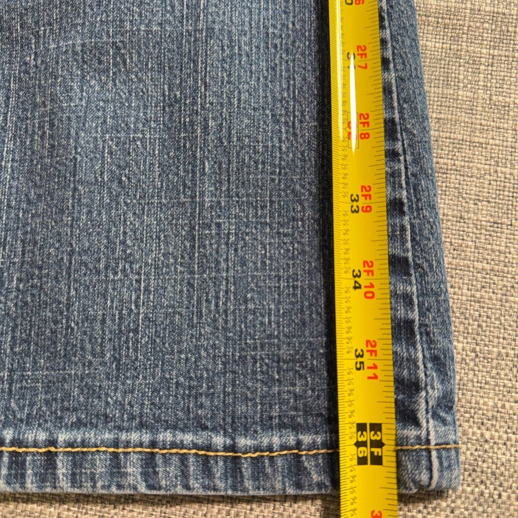 Second Half Supply Co, LLC blue stretch denim bootcut jeans leg with yellow measuring tape showing length