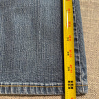 Second Half Supply Co, LLC blue stretch denim bootcut jeans leg with yellow measuring tape showing length