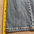 Second Half Supply Co, LLC blue stretch denim bootcut jeans leg with yellow measuring tape showing length