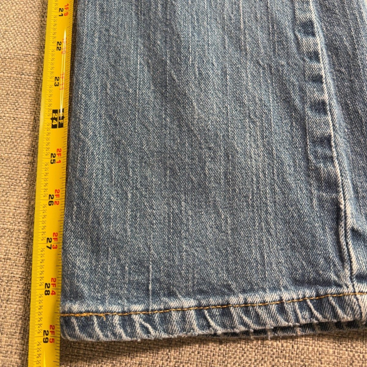 Second Half Supply Co, LLC blue stretch denim bootcut jeans leg with yellow measuring tape showing length