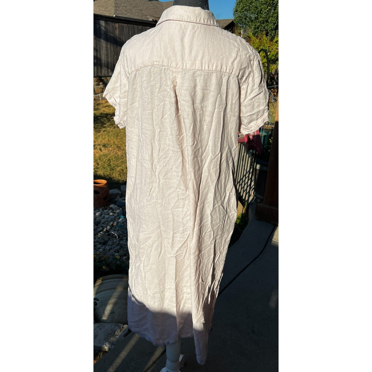 Back view of a blush pink C&C california midi shirt dress with short sleeves and textured fabric on a mannequin.