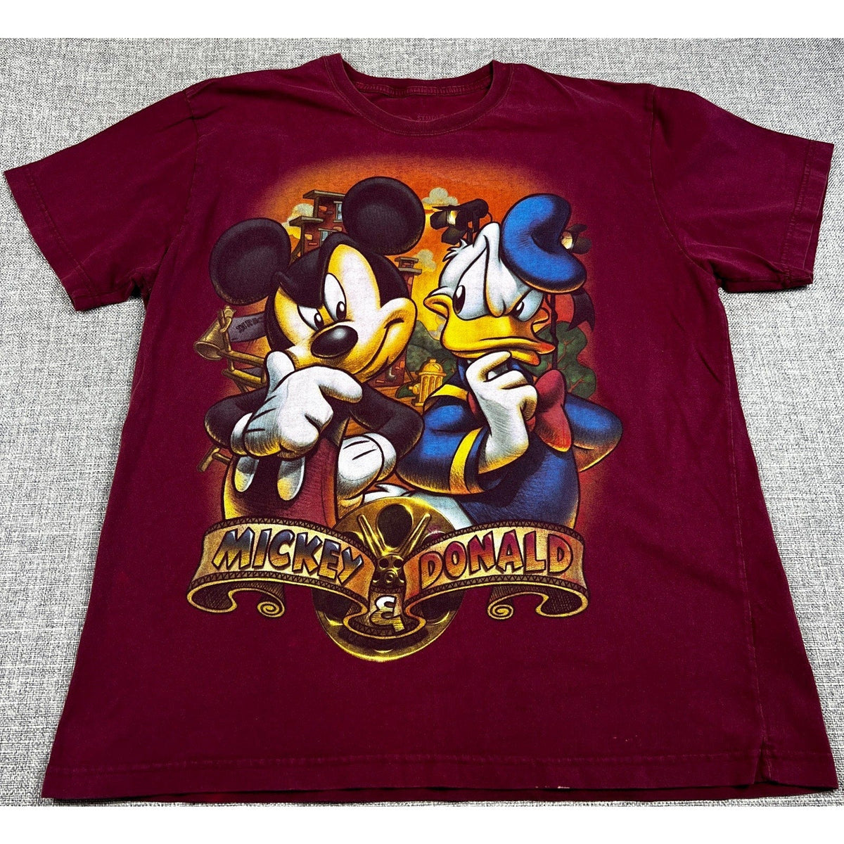 Second Half Supply Co, LLC burgundy cotton t-shirt featuring a distressed Mickey Mouse and Donald Duck city graphic.