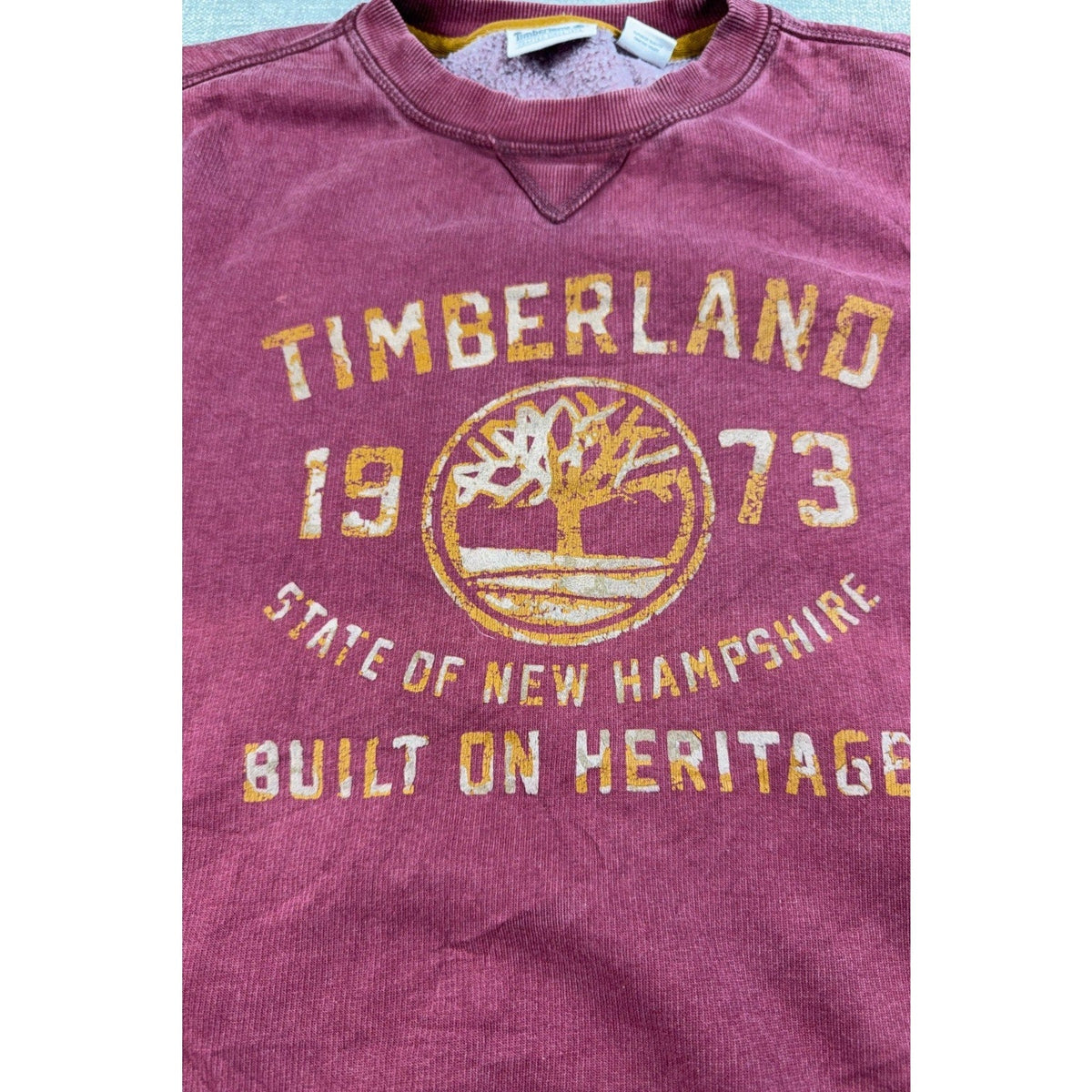 Second Half Supply Co, LLC burgundy Timberland crewneck sweatshirt with distressed 1973 heritage tree logo graphic.