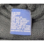 Second Half Supply Co, LLC blue care label on a dark green cotton knit sweater with washing instructions