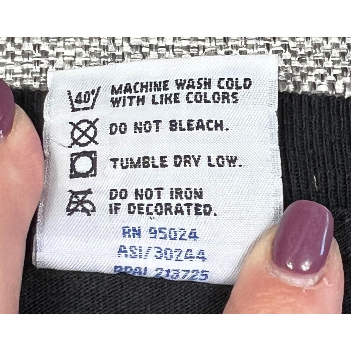Second Half Supply Co, LLC care label on a black heavyweight cotton T-shirt showing washing instructions