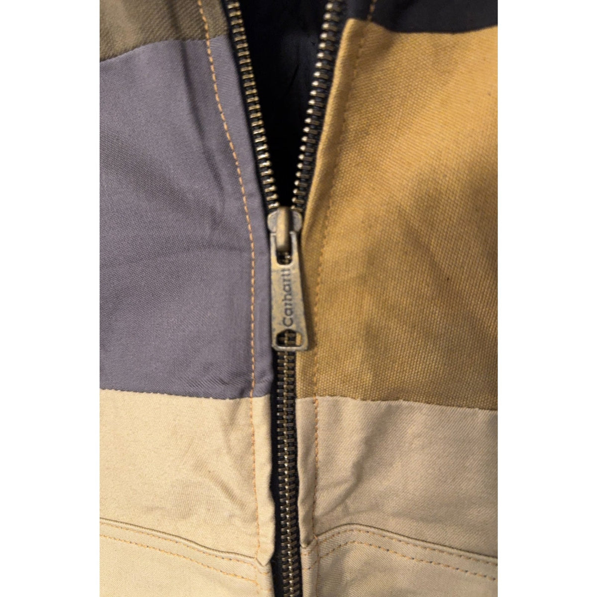 Second Half Supply Co, LLC reworked Carhartt jacket featuring a metal zipper pull on a multicolor patchwork panel
