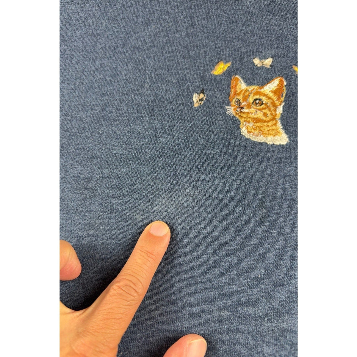 Second Half Supply Co, LLC navy blue sweatshirt with embroidered orange kitten and butterflies showing a small spot