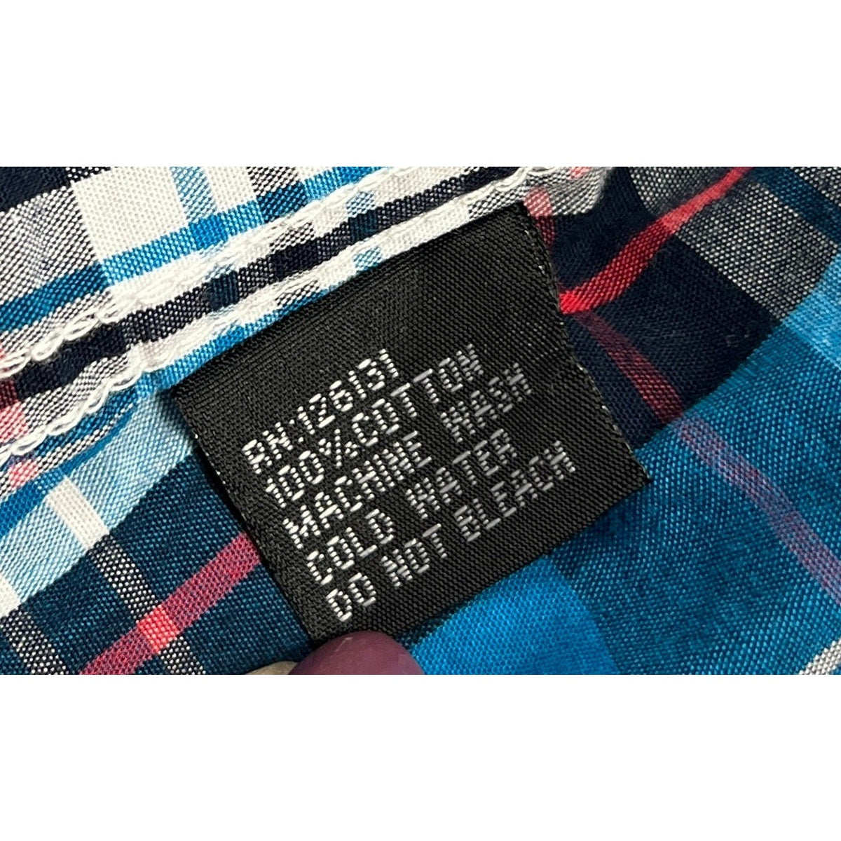 Second Half Supply Co, LLC cotton care label on a blue plaid Western shirt with 100% cotton and wash instructions