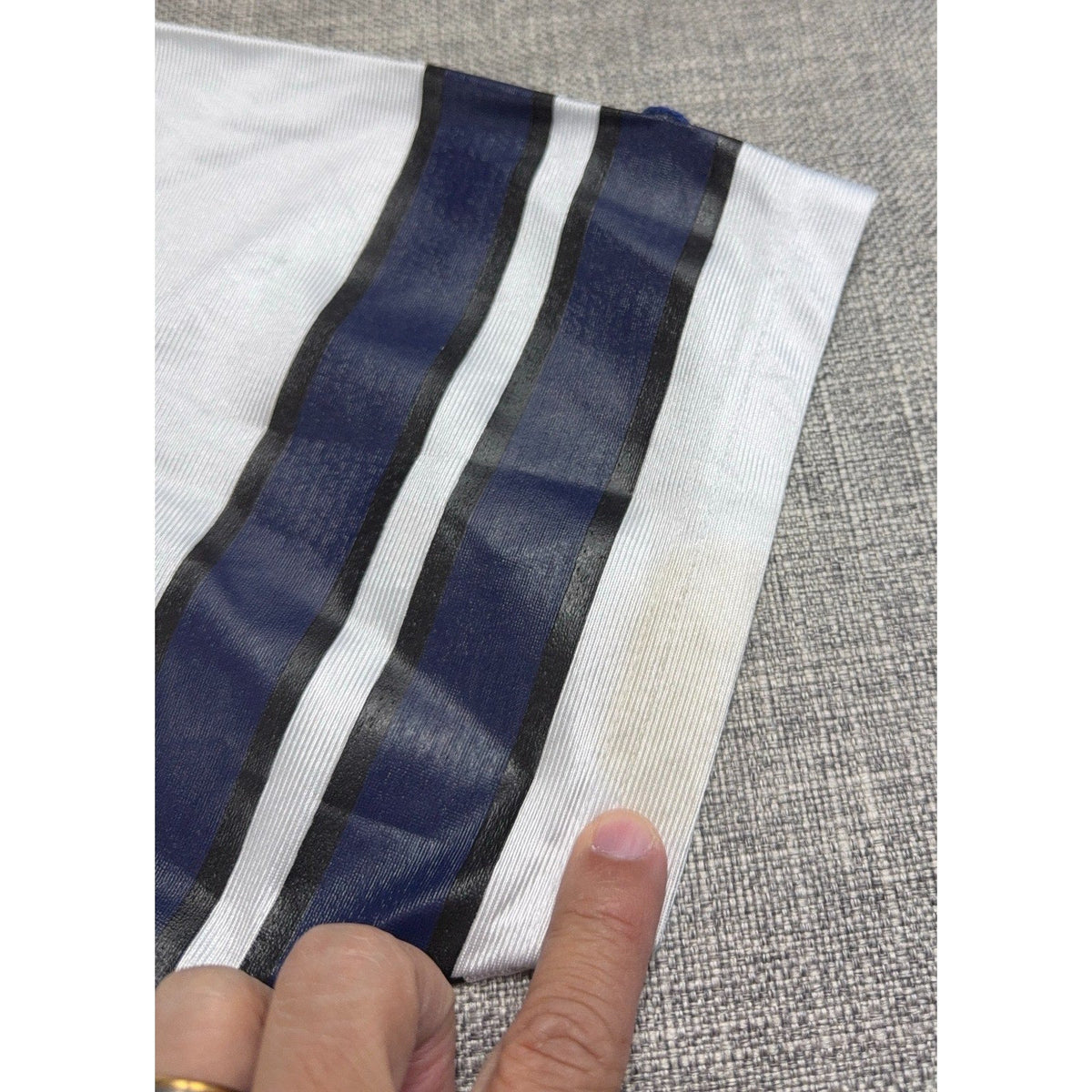 Second Half Supply Co, LLC vintage Dallas Cowboys jersey sleeve showing a small stain near the navy and black stripes