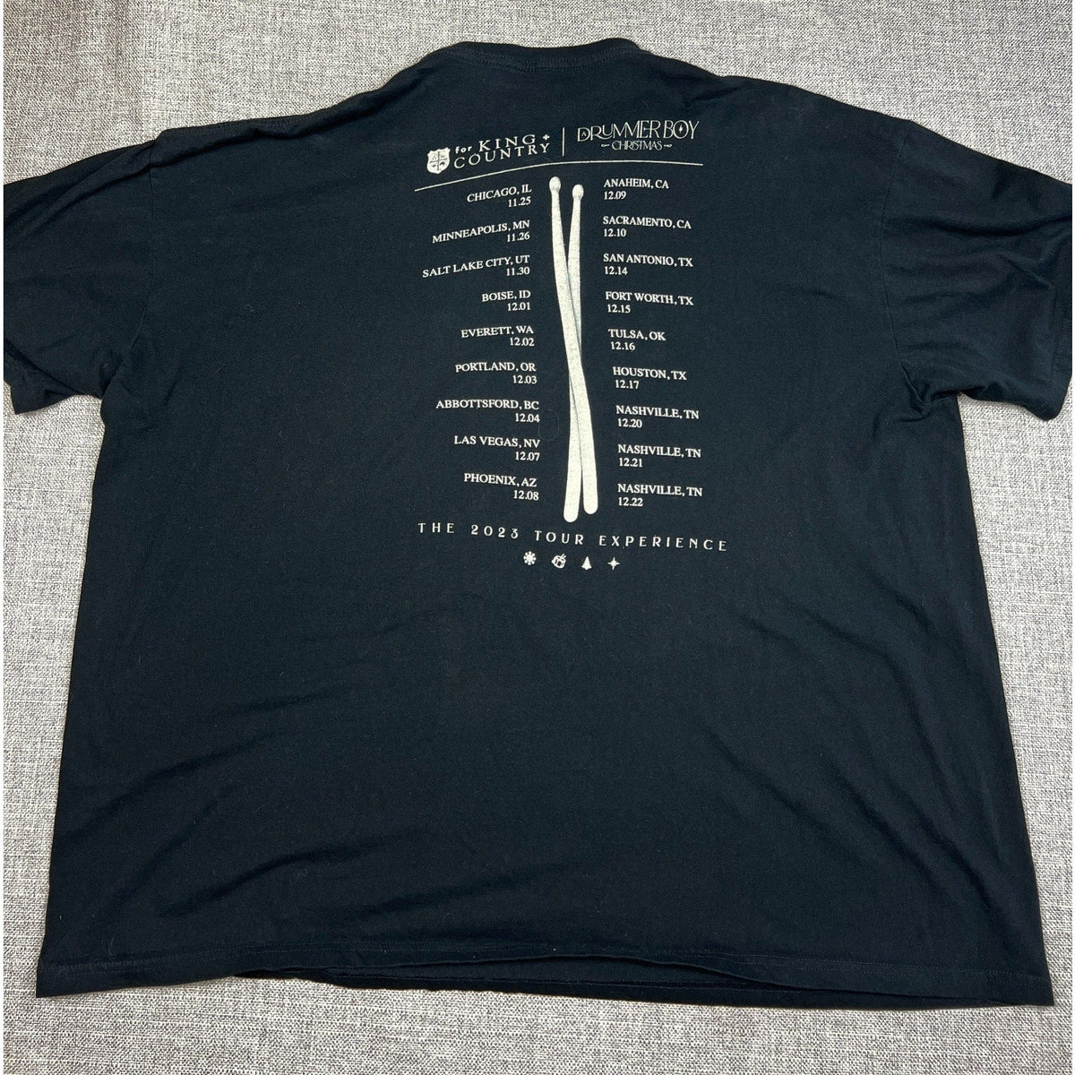 Second Half Supply Co, LLC black for KING + COUNTRY A Drummer Boy Christmas 2023 tour shirt back with city list