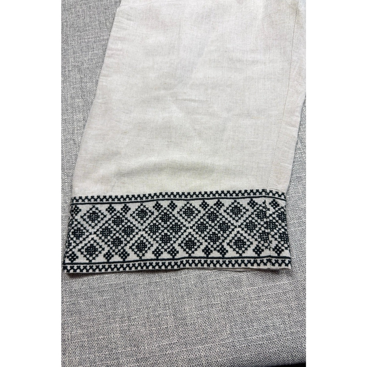 Second Half Supply Co, LLC cream wide-leg pants featuring intricate black geometric embroidery on the cropped hem