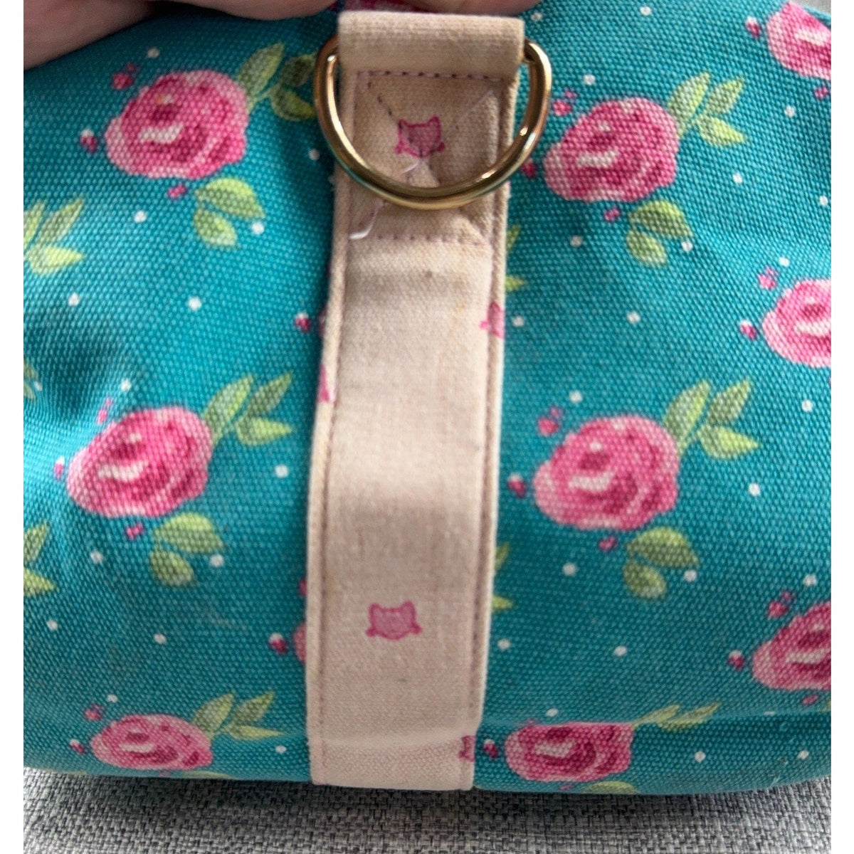 Second Half Supply Co, LLC floral canvas duffel bag in teal with pink roses, gold D-ring, and pale pink strap detail.