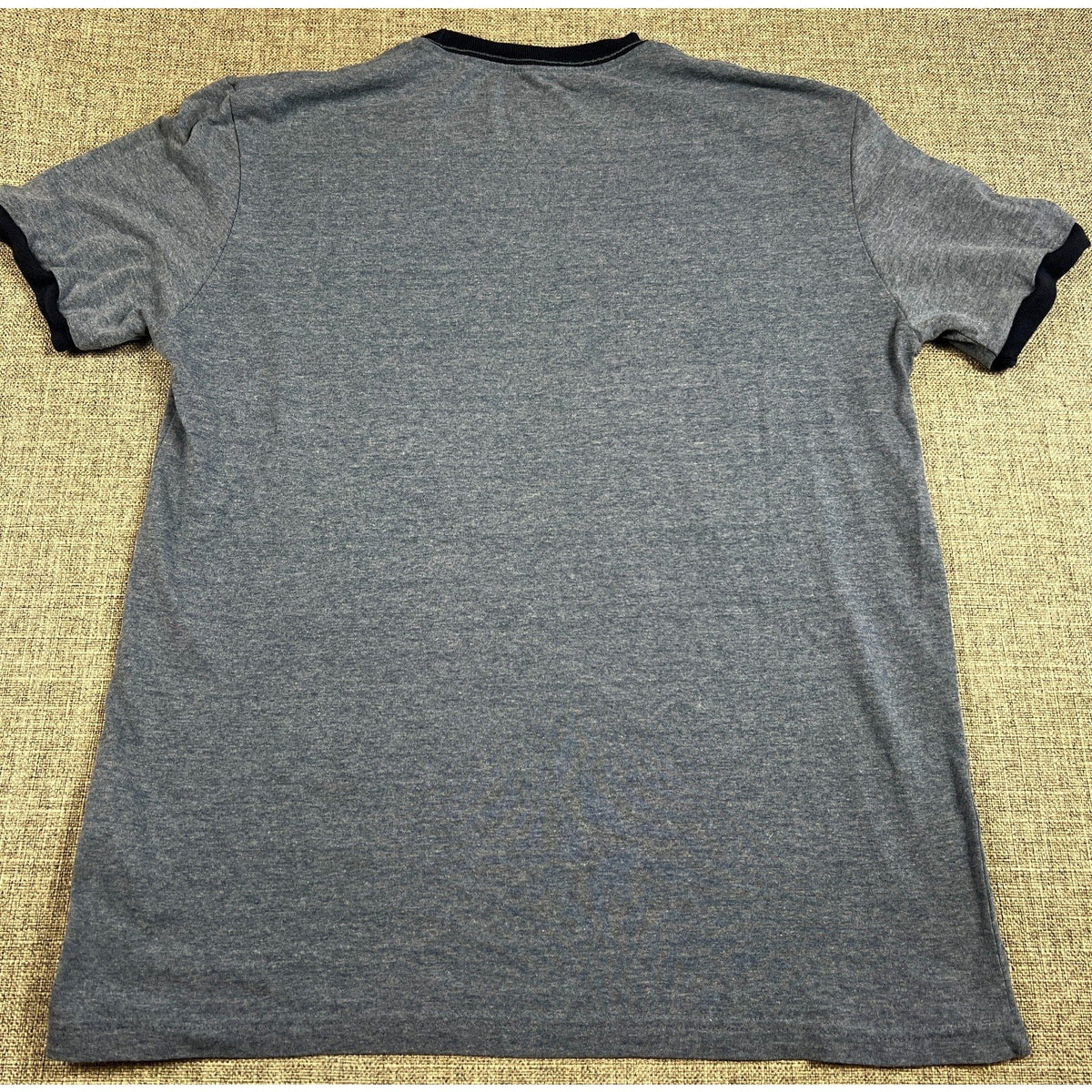 Back view of a Second Half Supply Co, LLC heather gray ringer T-shirt with navy blue trim on the sleeves and collar.