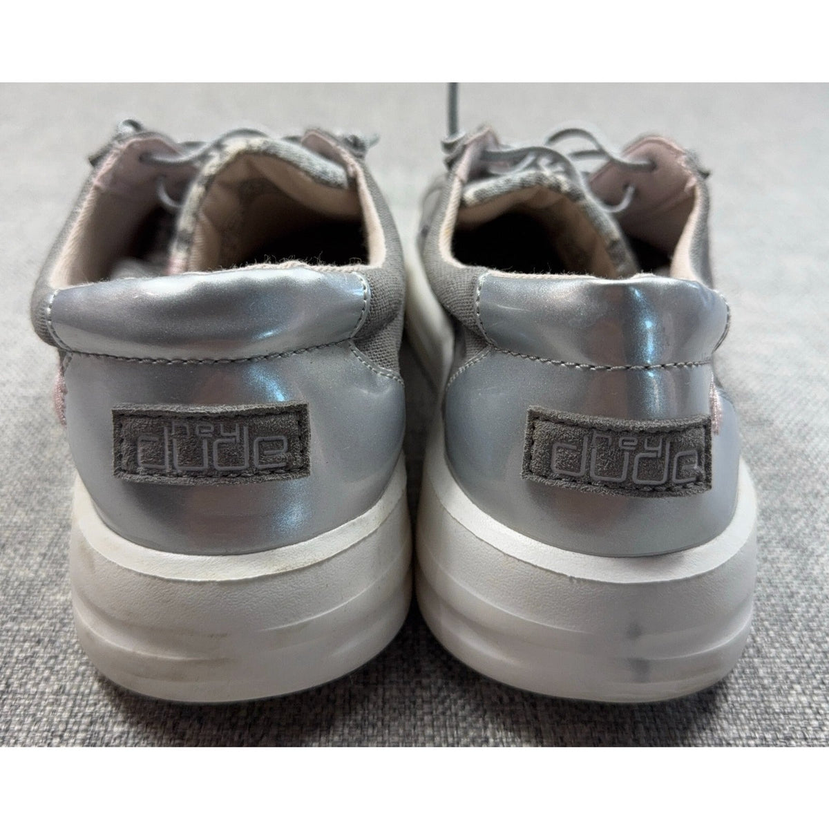 Second Half Supply Co, LLC Hey Dude Karina silver metallic slip-on sneakers with white soles, rear view