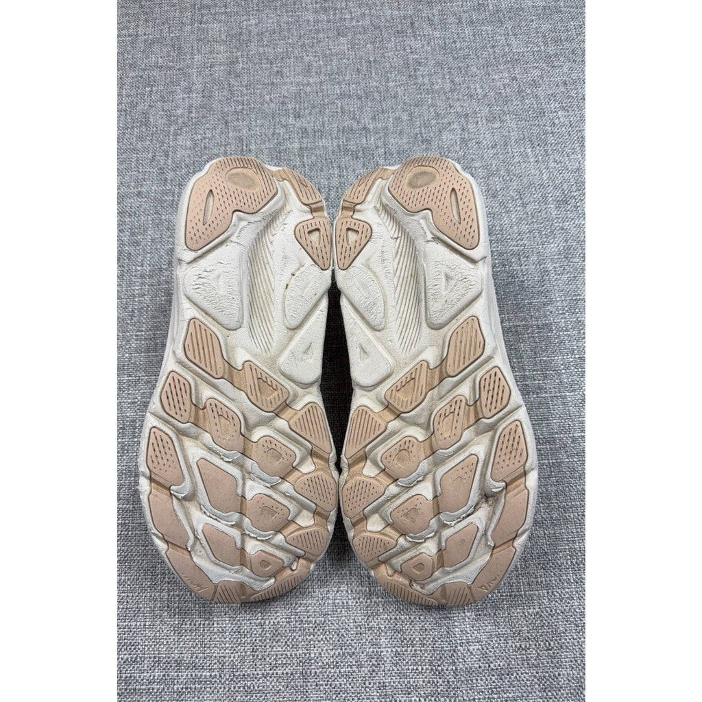 Outsole view of Second Half Supply Co, LLC HOKA Clifton 9 running shoes in shifting sand and eggnog with wear