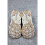 Outsole view of Second Half Supply Co, LLC HOKA Clifton 9 running shoes in shifting sand and eggnog with wear