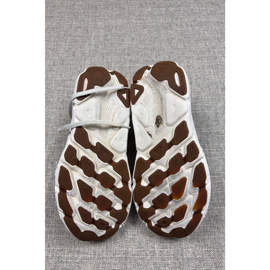 Second Half Supply Co, LLC HOKA Clifton 9 running shoes showing worn white midsoles and brown rubber traction outsoles