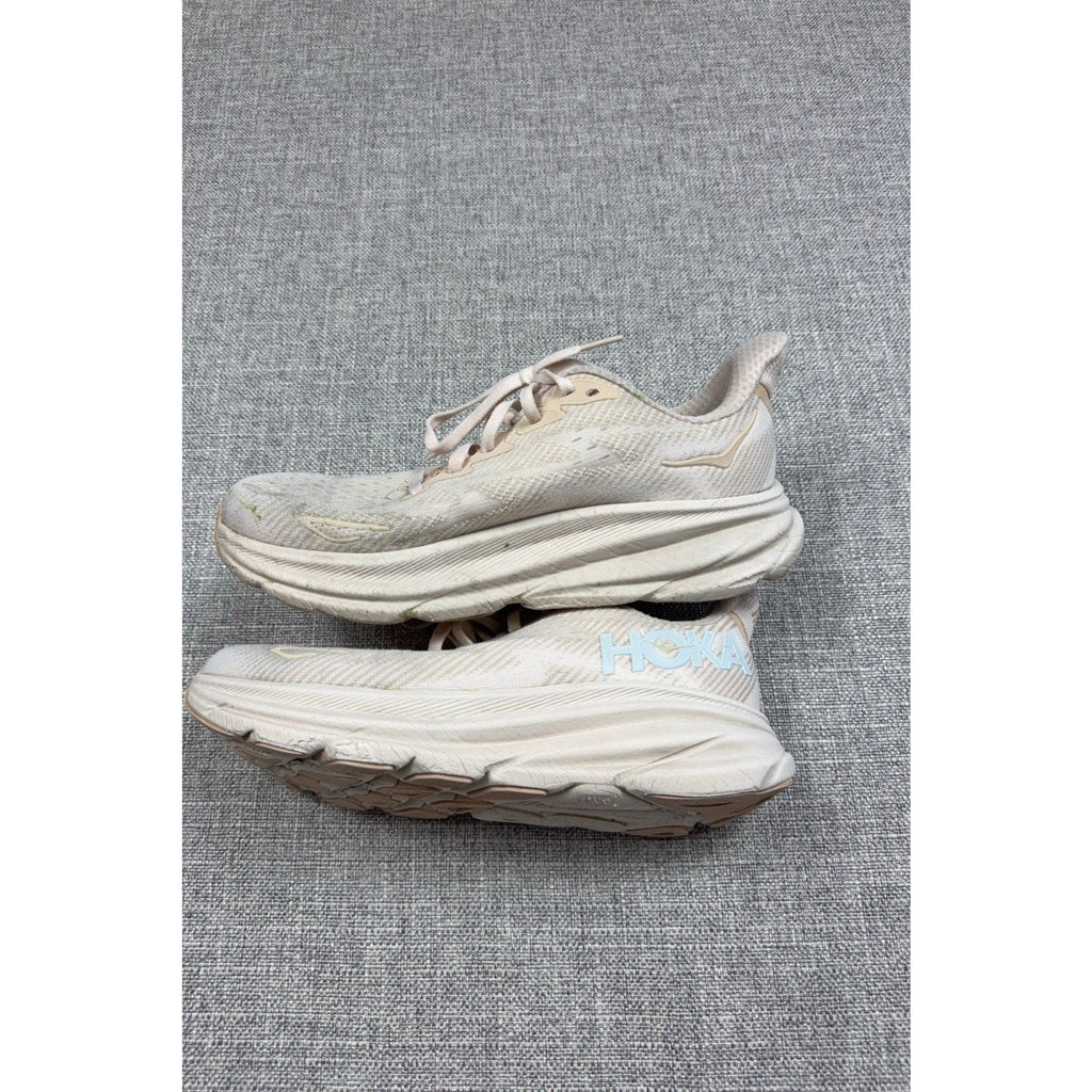 Second Half Supply Co, LLC HOKA Clifton 9 women's running shoes in shifting sand and eggnog with cushioned midsoles.