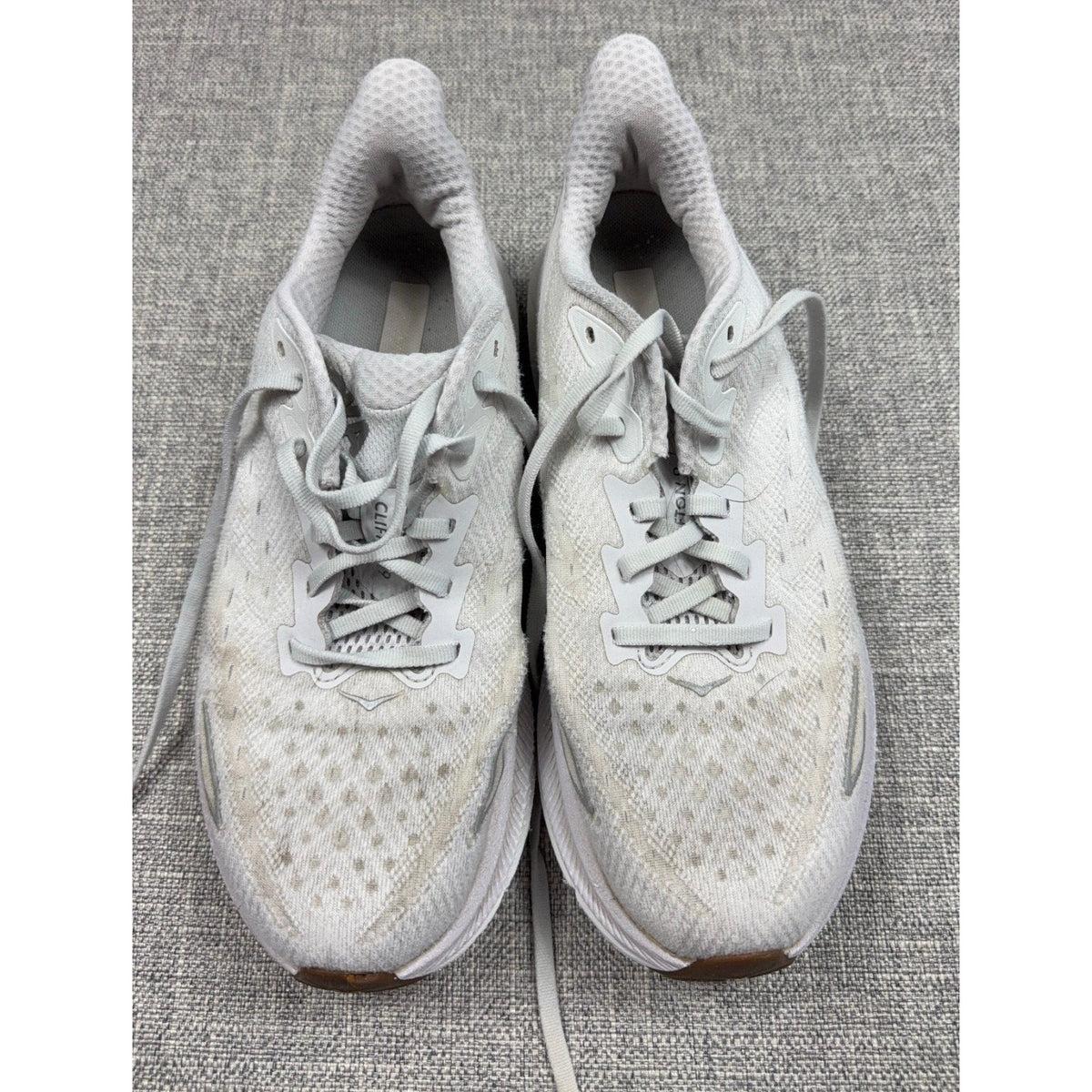 Second Half Supply Co, LLC pre-owned white HOKA Clifton 9 women's running shoes with knit uppers and cushioned midsoles.