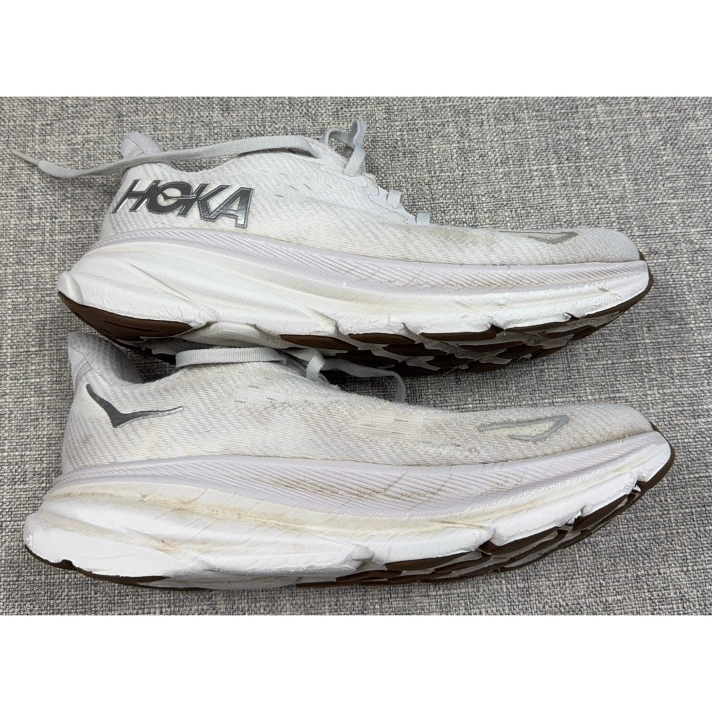 Second Half Supply Co, LLC white HOKA Clifton 9 running shoes with visible wear, discoloration, and scuffs on midsoles.