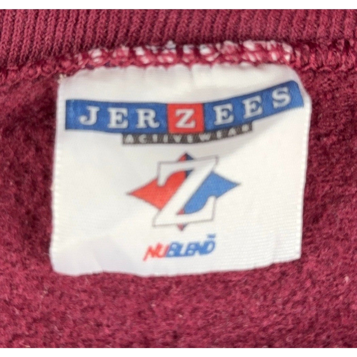 Second Half Supply Co, LLC vintage Jerzees NuBlend sweatshirt tag on burgundy fleece fabric