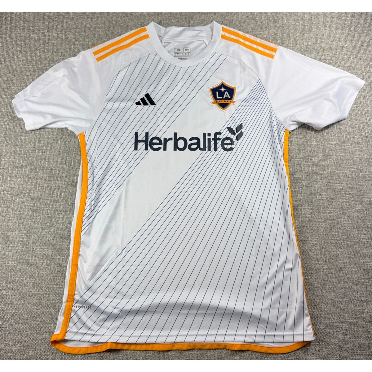 Second Half Supply Co, LLC Adidas LA Galaxy 2024-25 white soccer jersey with gold stripes and Herbalife sponsor