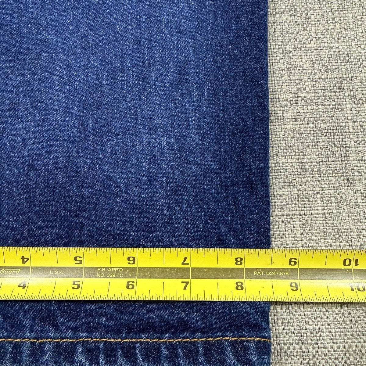 Second Half Supply Co, LLC dark wash denim fabric with yellow measuring tape showing leg opening width