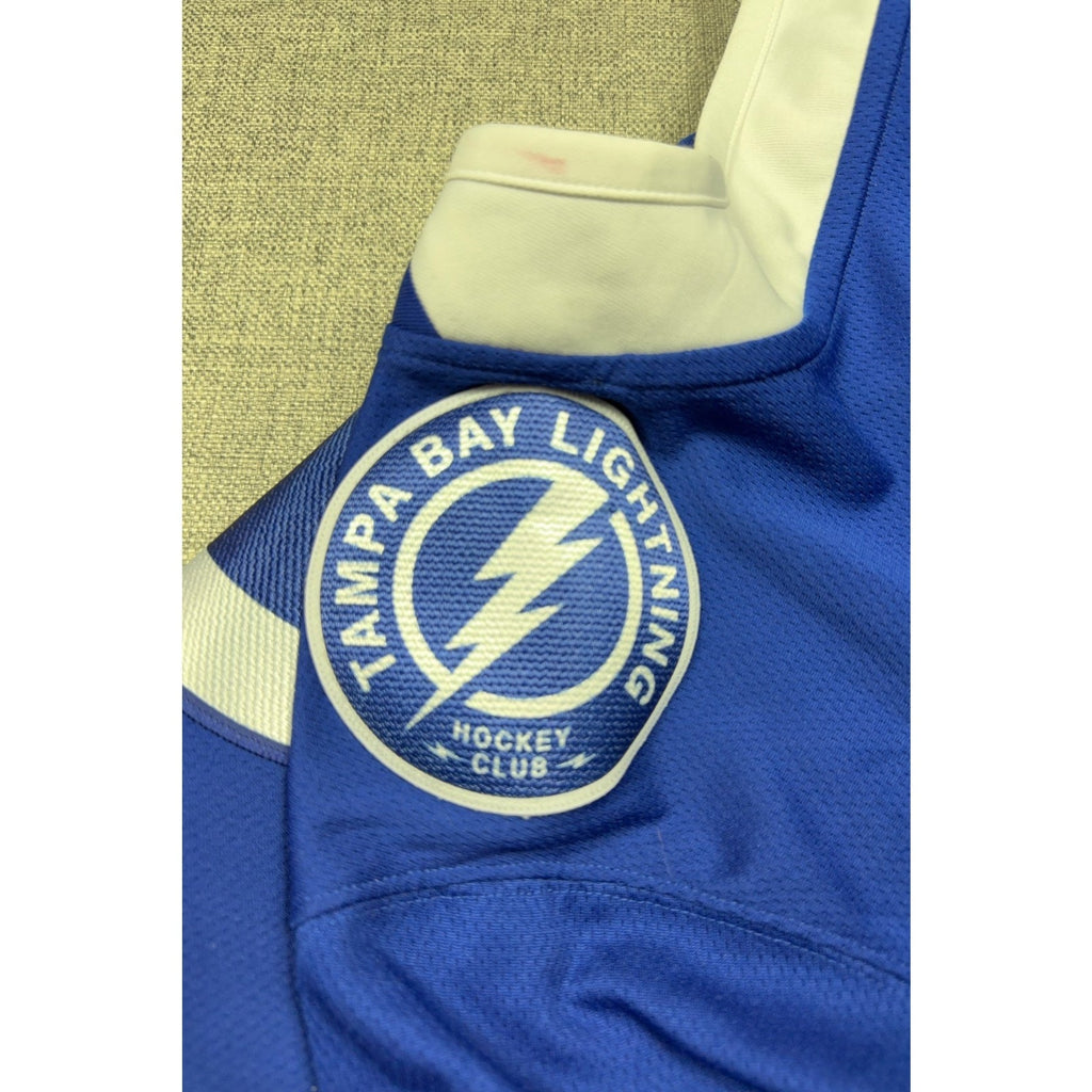 Second Half Supply Co, LLC Tampa Bay Lightning hockey jersey shoulder patch with visible collar mark on blue fabric