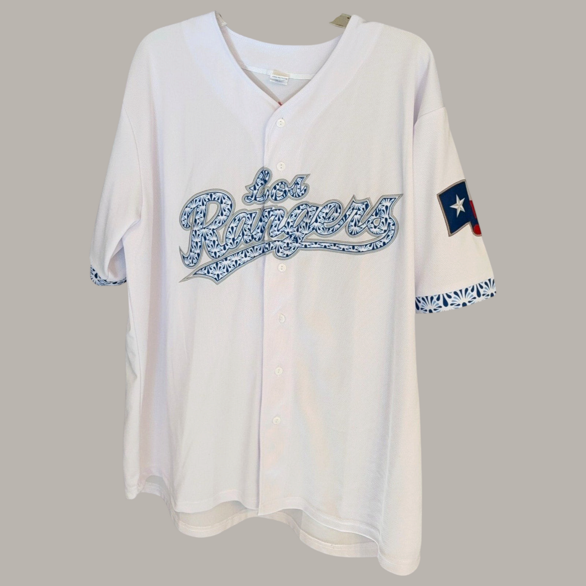 Second Half Supply Co, LLC white Los Rangers baseball jersey with blue Talavera-inspired script and Texas flag sleeve patch