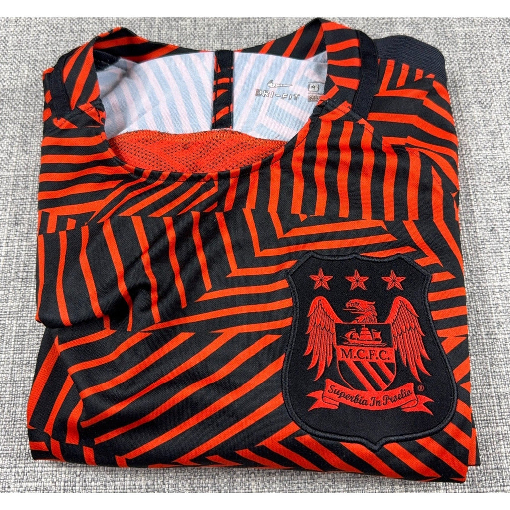 Second Half Supply Co, LLC Manchester City Nike Dri-FIT soccer shirt in red and black with geometric pattern and crest