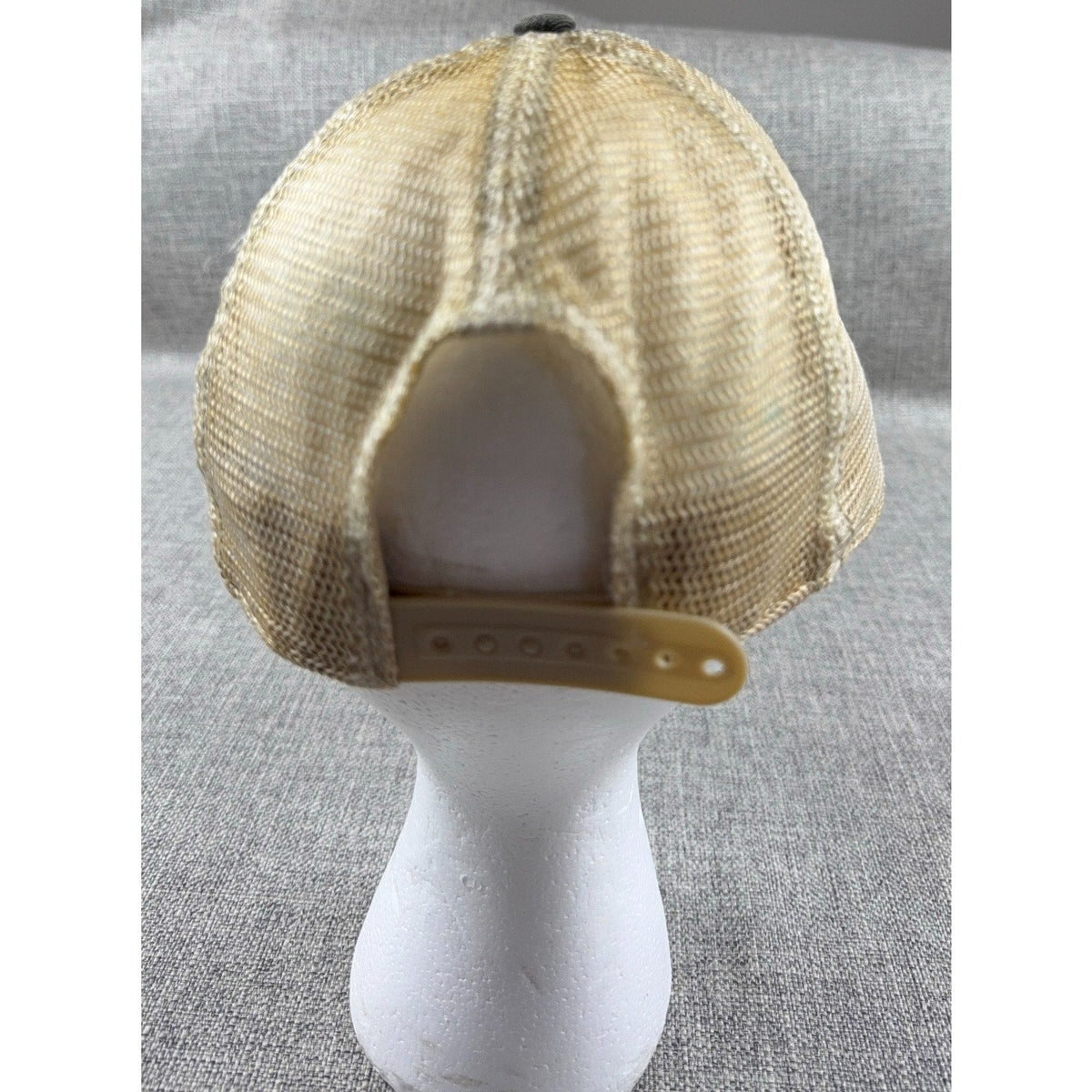 Back view of a Second Half Supply Co, LLC distressed tan mesh trucker hat with an adjustable snapback closure