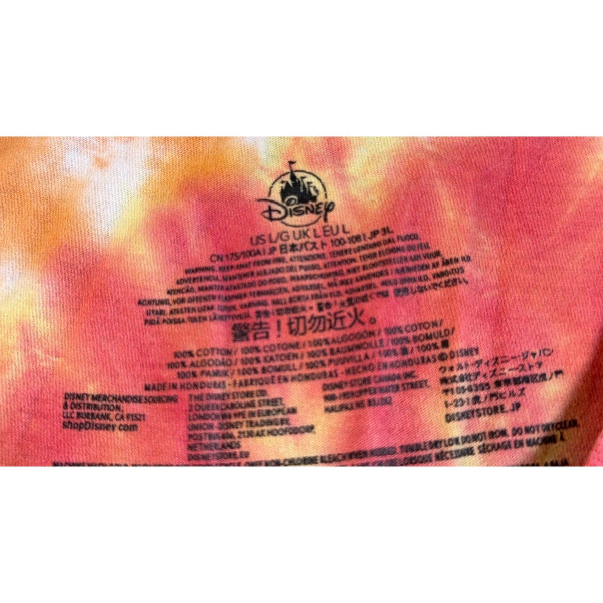 Second Half Supply Co, LLC Disney Store Mickey Mouse t-shirt interior neck label on rainbow tie-dye cotton fabric