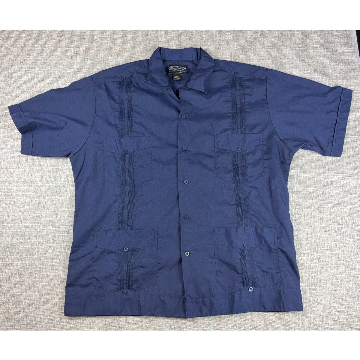 Second Half Supply Co, LLC navy blue cotton guayabera shirt with four pockets and vertical pleated detailing.